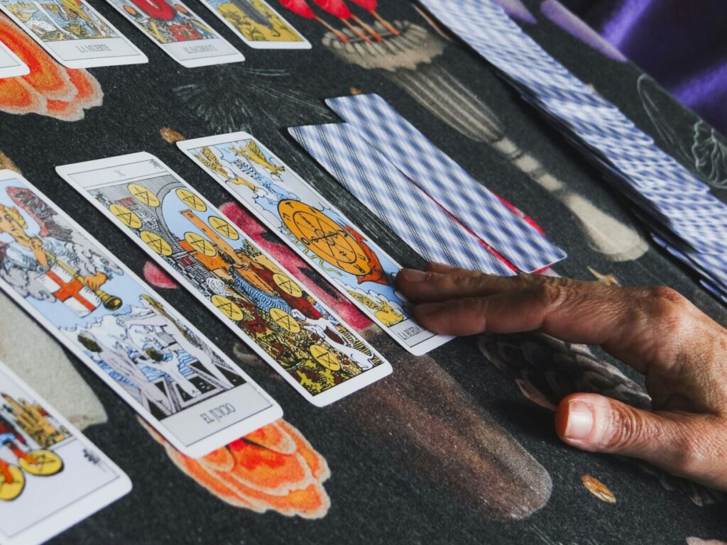 Mano sobre una tirada de cartas del tarot extendida en la mesa